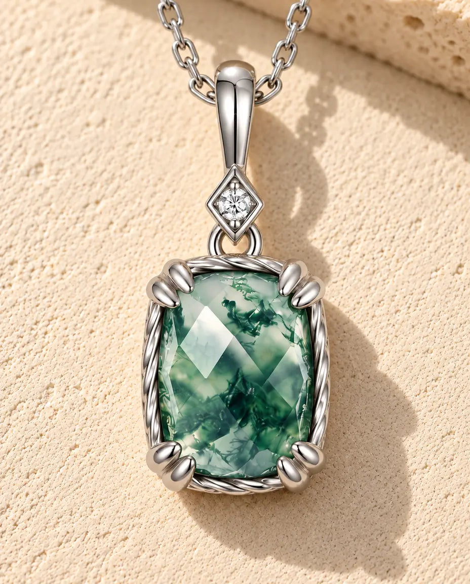 Moss Agate Pendant Necklace in 925 Sterling Silver - lying on a cream textured surface beside a travertine block