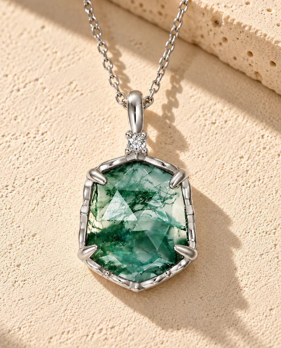 Hexagon Moss Agate Necklace in 925 Sterling Silver - lying on a cream textured surface beside a travertine block