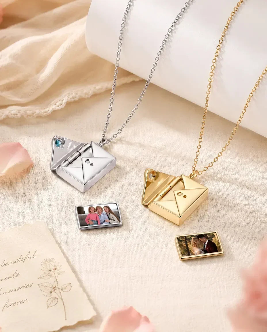 Personalised envelope photo locket necklaces in silver and gold, opened with slide-out photo cards and heart birthstones