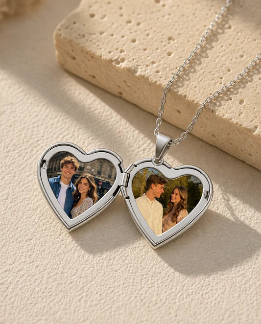 Silver heart locket necklace open to show two custom photos side by side in warm flat-lay scene