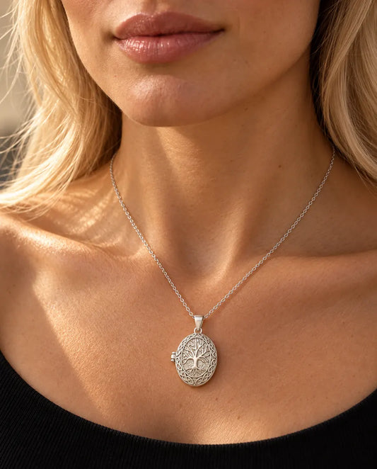Woman in a black knit top wearing the silver tone tree of life photo locket necklace