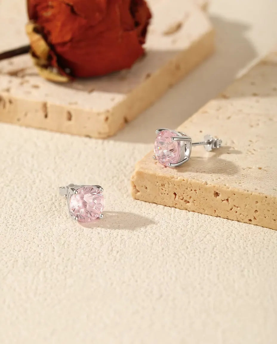 Pink Cubic Zirconia Stud Earrings in 925 Sterling Silver - the pair on a cream stone surface