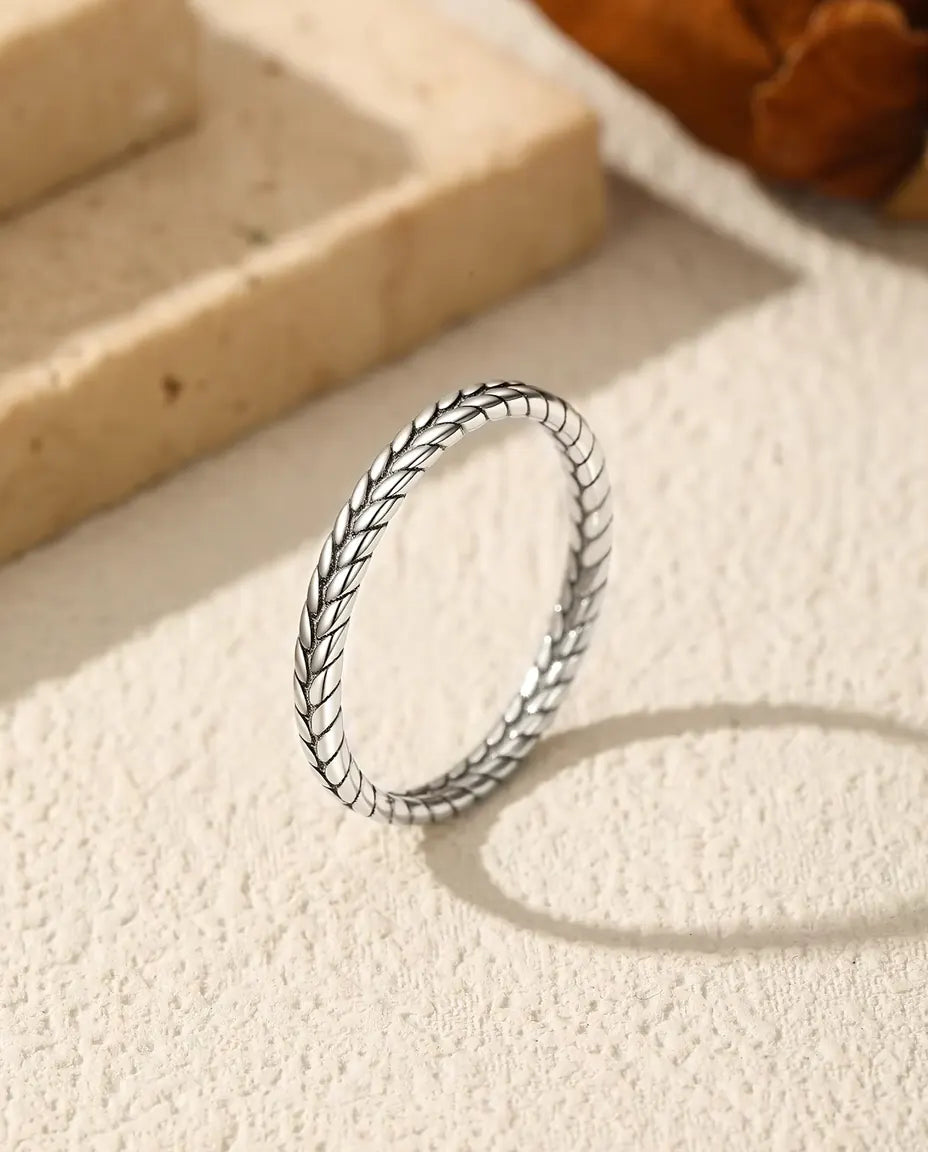 Wheat Ring in 925 Sterling Silver - standing upright on a cream textured surface