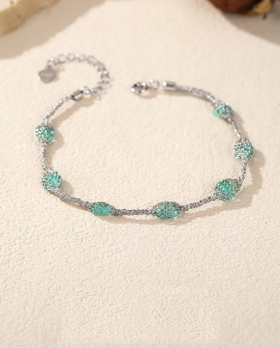 Caged Zircon Bracelet in 925 Sterling Silver - laid flat on a cream textured surface with the clasp and extender