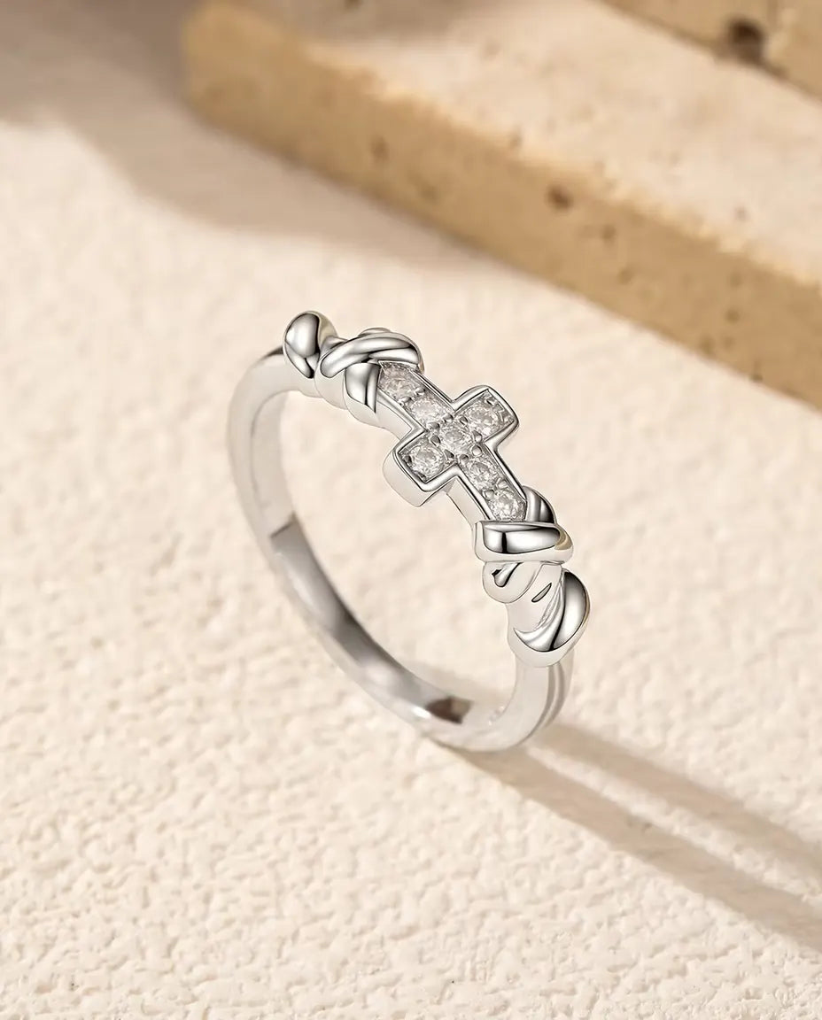 Cross Moissanite Ring in 925 Sterling Silver - standing upright on a cream textured surface