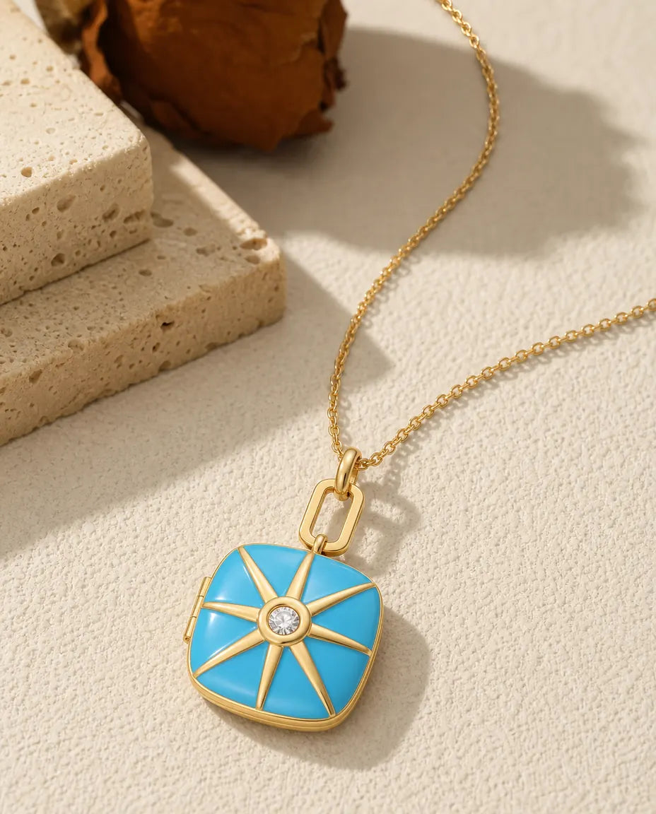 Turquoise enamel photo locket necklace with a gold starburst and crystal center