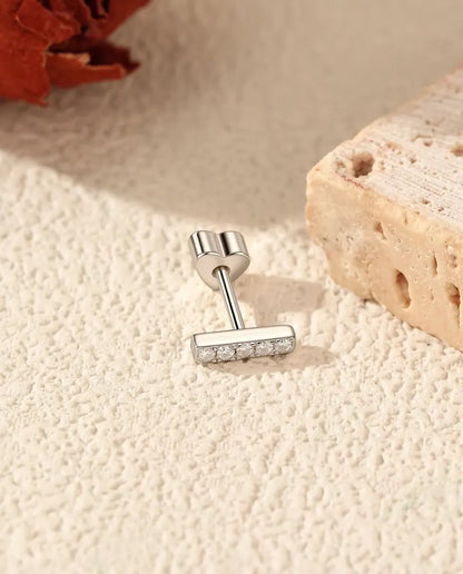 Moissanite Bar Stud Earrings in 925 Sterling Silver - lying on the edge of a travertine slab, back attached