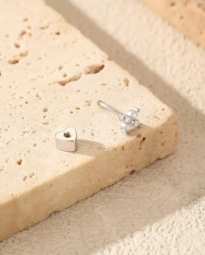 Four-Stone Moissanite Clover Stud Earrings in 925 Sterling Silver - resting on a travertine slab, back taken off