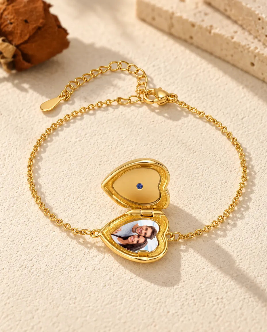 Heart locket bracelet open with one photo in the base and a plain gold lid