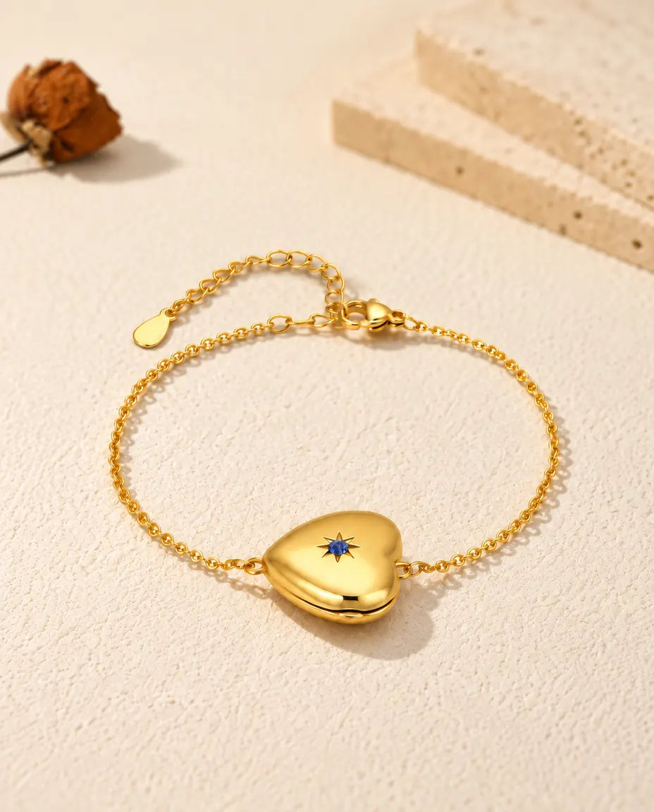 Closed heart locket bracelet from a low angle, star-set birthstone on the front