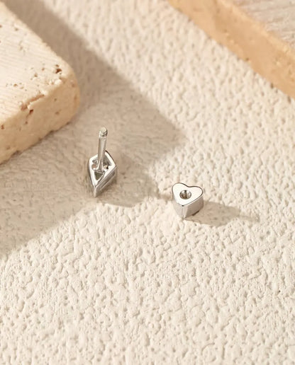 Kite Cut Moissanite Stud Earrings in 925 Sterling Silver - with the heart-shaped back taken off and set beside it