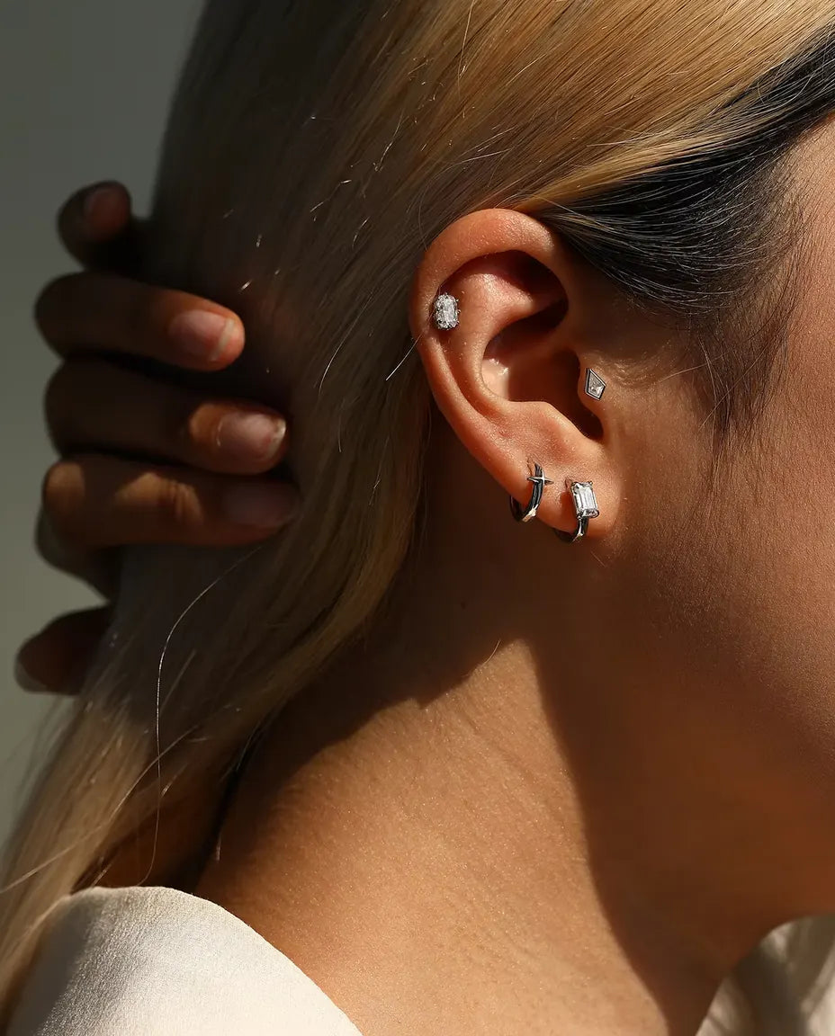 Kite Cut Moissanite Stud Earrings in 925 Sterling Silver - worn on a model with her hand at the back of her head