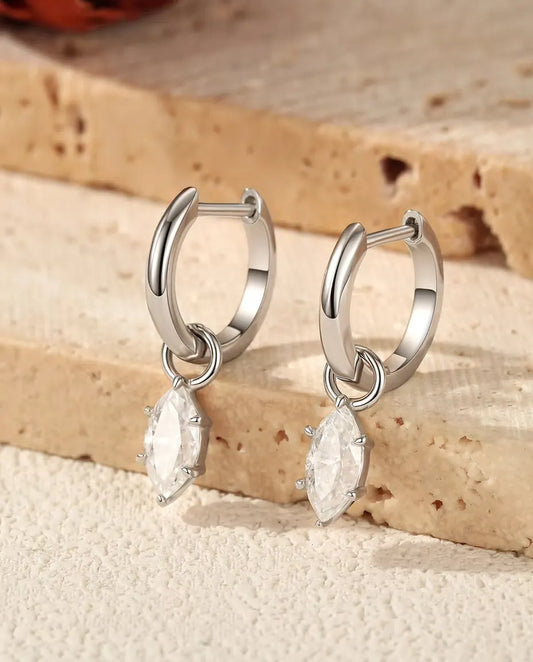 Marquise Moissanite Charm Huggie Hoop Earrings in 925 Sterling Silver - the pair resting on travertine steps