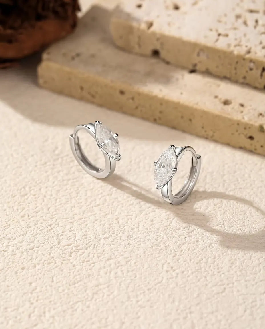 Moissanite Hoop Earrings in 925 Sterling Silver - pair standing side by side on a cream textured surface