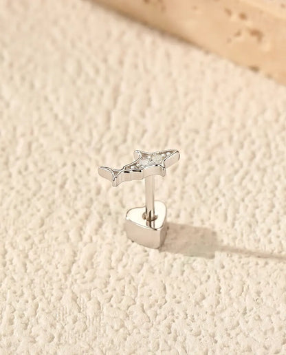Shark Stud Earrings in 925 Sterling Silver with Moissanite - standing upright on its heart-shaped back on a cream textured surface