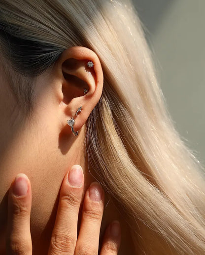 Shark Stud Earrings in 925 Sterling Silver with Moissanite - worn on a model with her hand at her neck