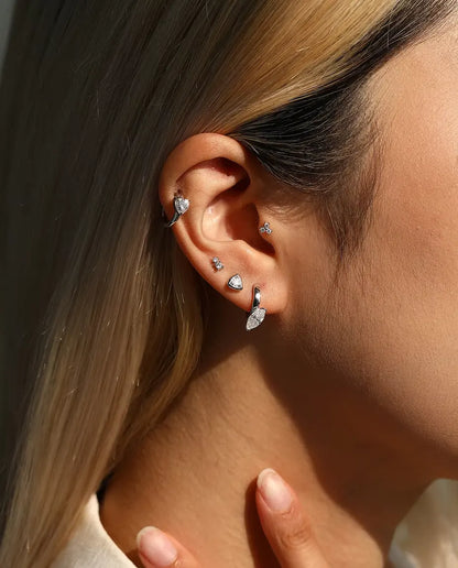 Three-Stone Moissanite Trefoil Stud Earrings in 925 Sterling Silver - worn on a model with her hand at her neck