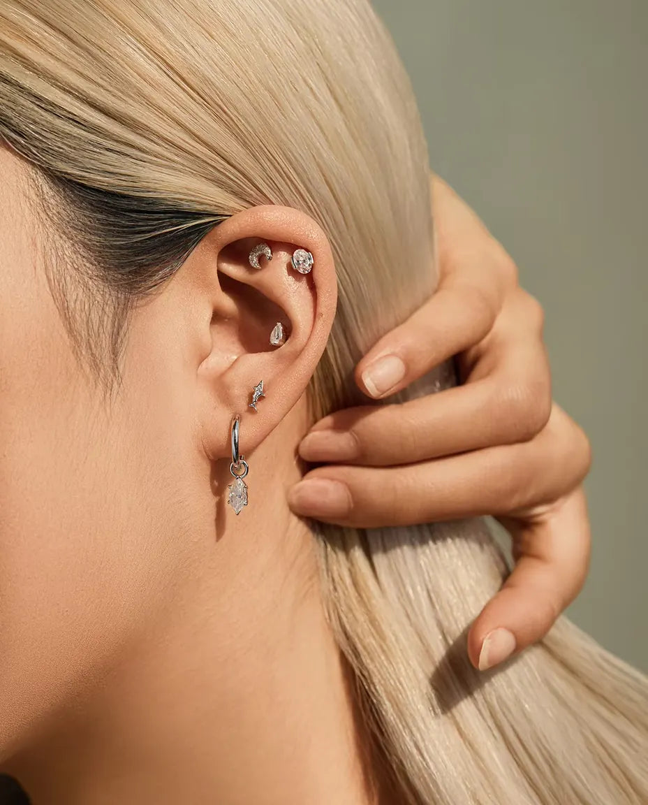 Oval Moissanite Stud Earrings in 925 Sterling Silver - worn on a model tucking her hair behind her ear
