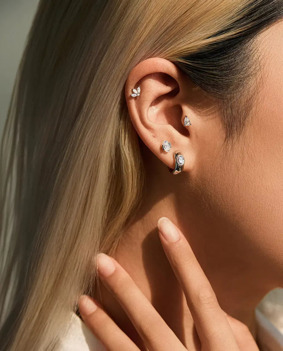 Oval Moissanite Stud Earrings in 925 Sterling Silver - worn on a model with her hand at her neck