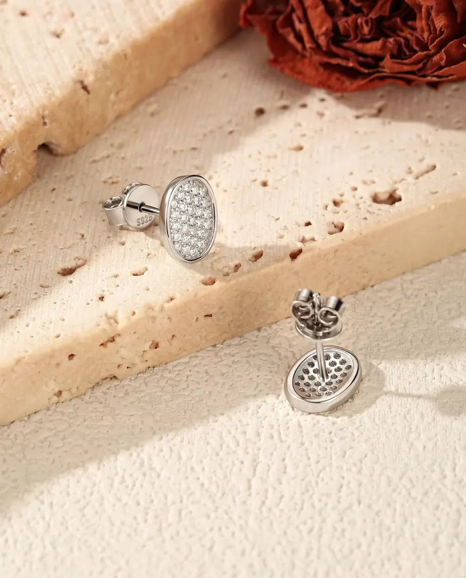 Oval Pave Moissanite Stud Earrings in 925 Sterling Silver - one face up and one turned to show the post and butterfly back