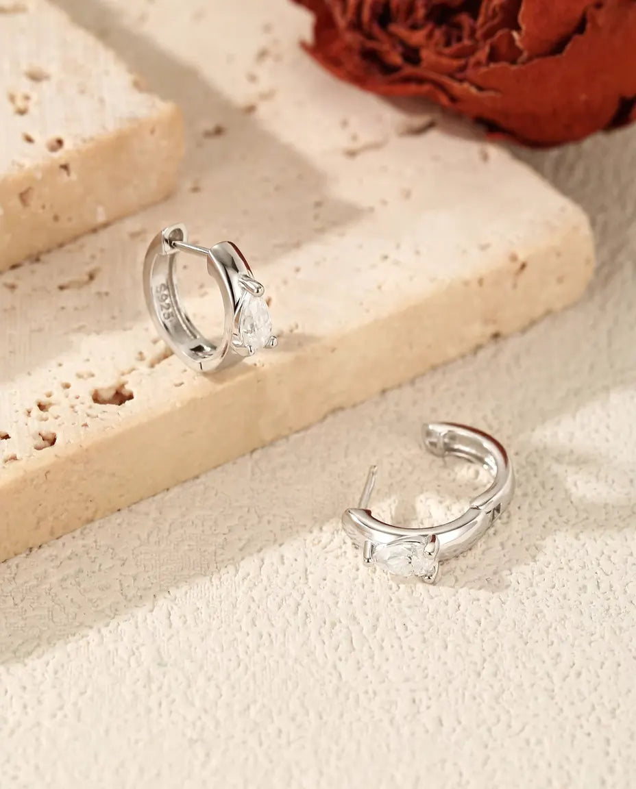 Pear Moissanite Huggie Hoop Earrings in 925 Sterling Silver - one hoop standing and one lying on its side