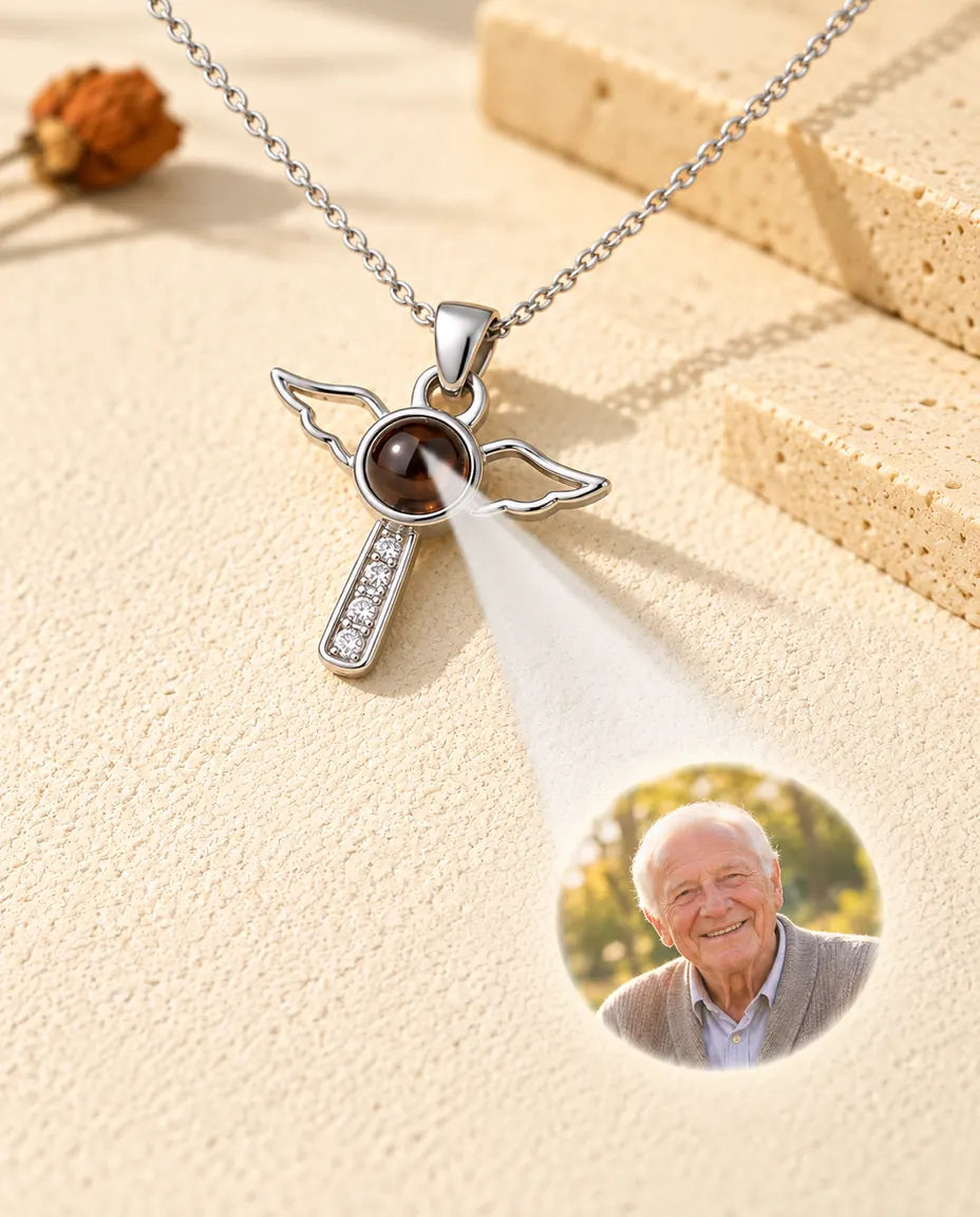 Silver tone angel wings cross projecting a portrait of an elderly man onto plaster