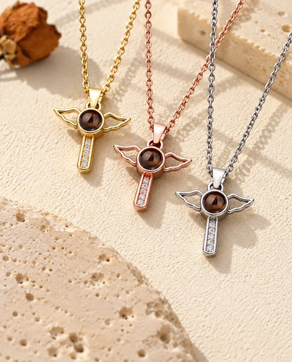 Gold tone, rose gold tone and silver tone winged crosses hanging side by side