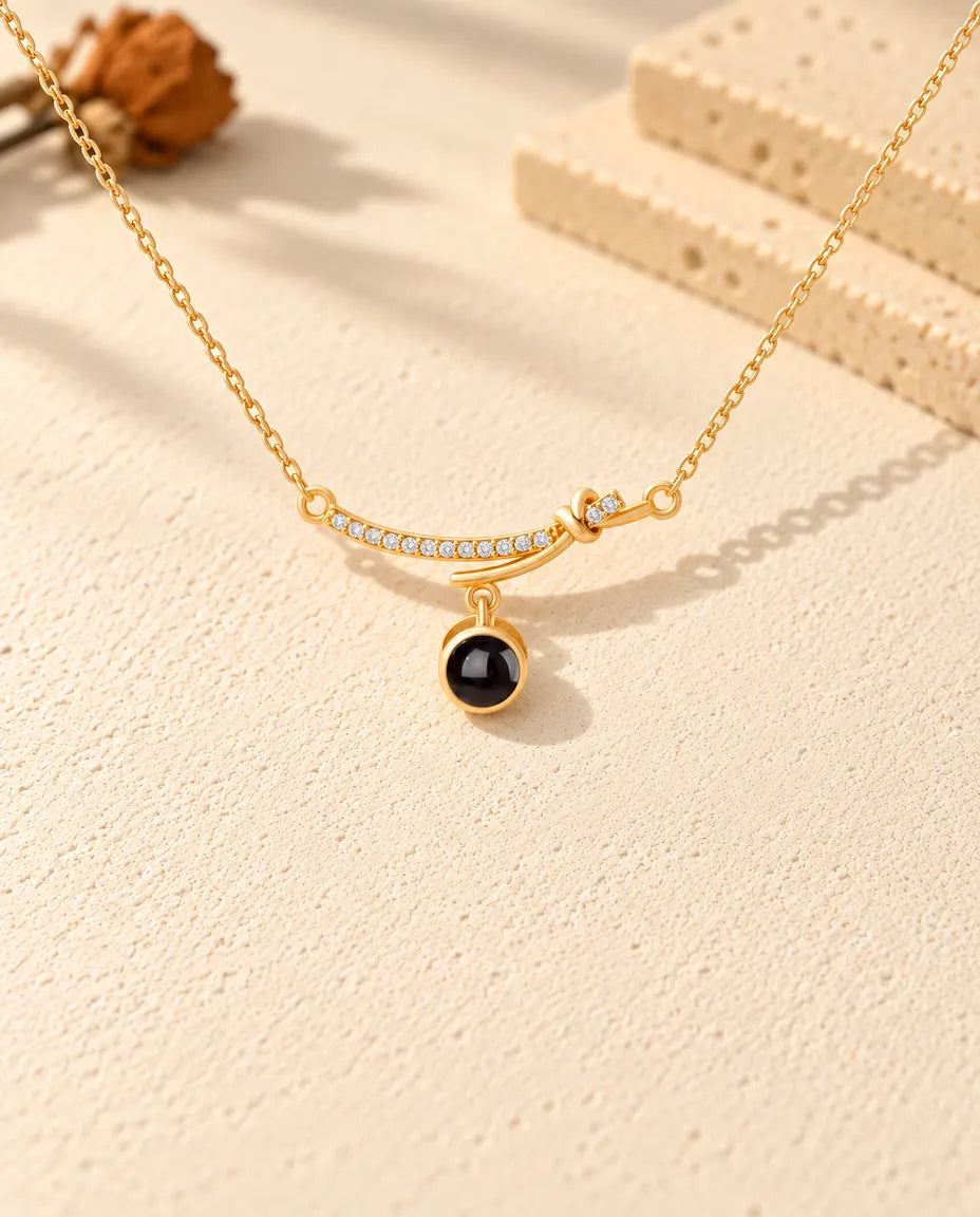 Front view of the gold tone cubic zirconia bar with the dangling projection stone