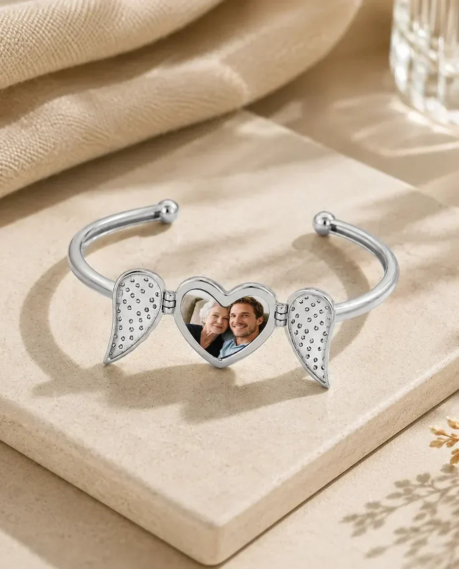 Silver heart photo bangle with angel wings opened to show the picture inside
