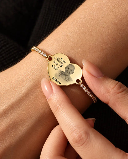 Fingertips holding the gold tone engraved photo heart on the wrist