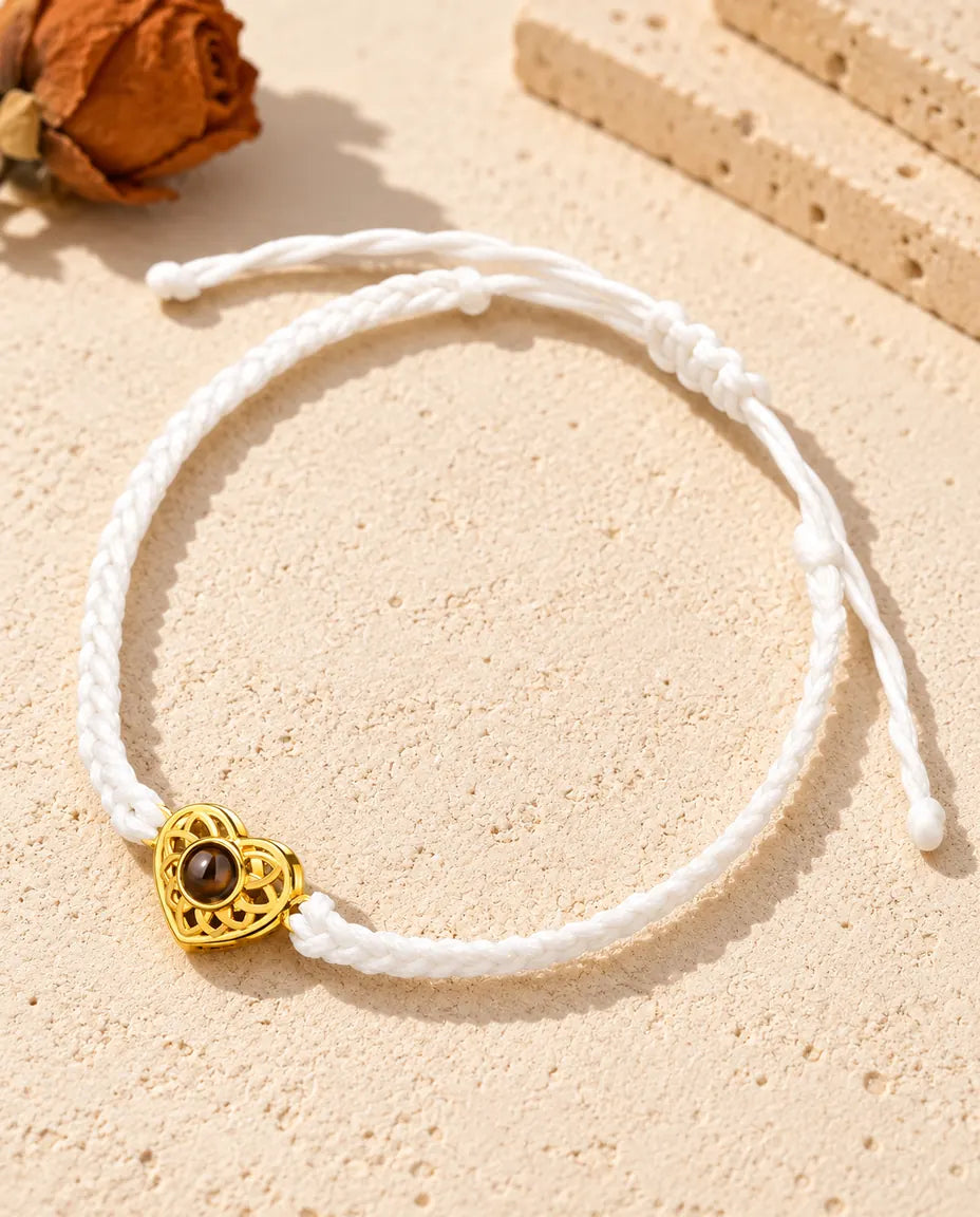 White thin braided cord photo projection bracelet with a gold tone heart charm and sliding knot closure
