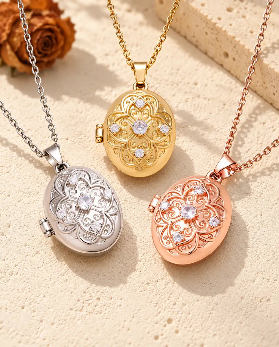 Three colours of the oval filigree photo locket necklace arranged on plaster