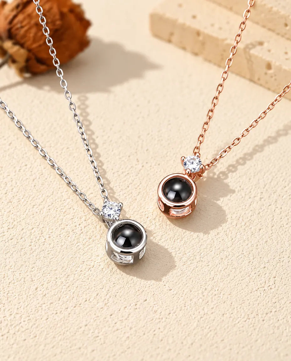 Silver tone and rose gold tone solitaire projection necklaces side by side
