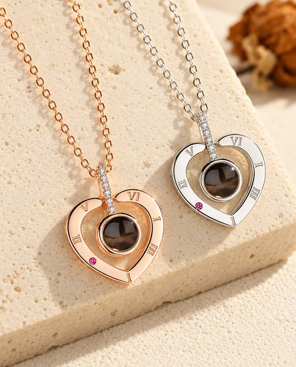 Rose gold tone and silver Roman numeral heart projection necklaces side by side
