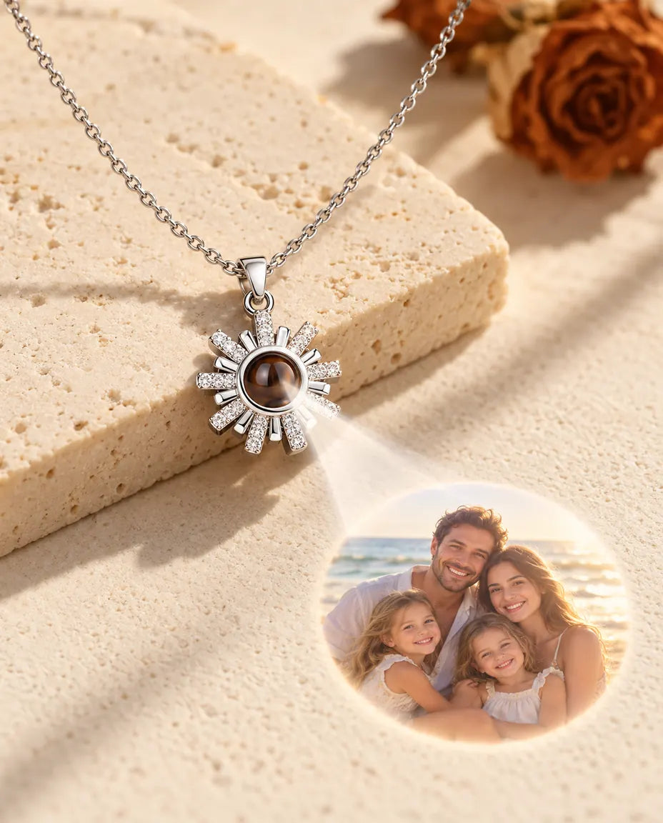 Silver tone sunburst necklace projecting a family beach photo onto cream plaster