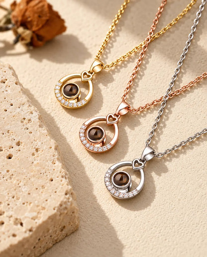 Three teardrop necklaces stacked diagonally with cubic zirconia arcs