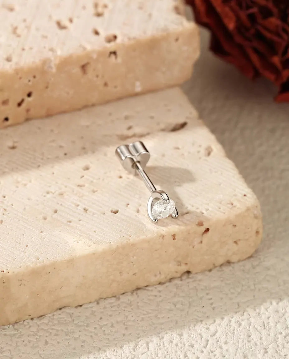 Round Moissanite Stud Earrings in 925 Sterling Silver - lying on the edge of a travertine slab, back attached