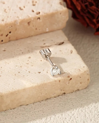 Round Moissanite Stud Earrings in 925 Sterling Silver - lying on the edge of a travertine slab, back attached
