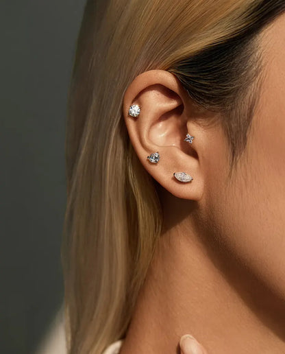 Round Moissanite Four-Prong Stud Earrings in 925 Sterling Silver - worn on a model, wider view of ear and neck