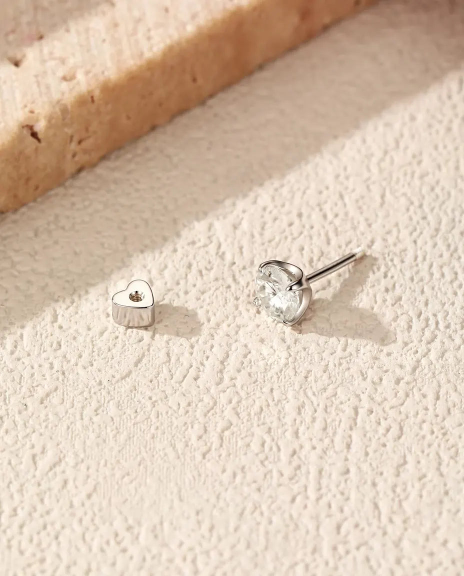 Round Moissanite Four-Prong Stud Earrings in 925 Sterling Silver - with the heart-shaped back taken off and set beside it