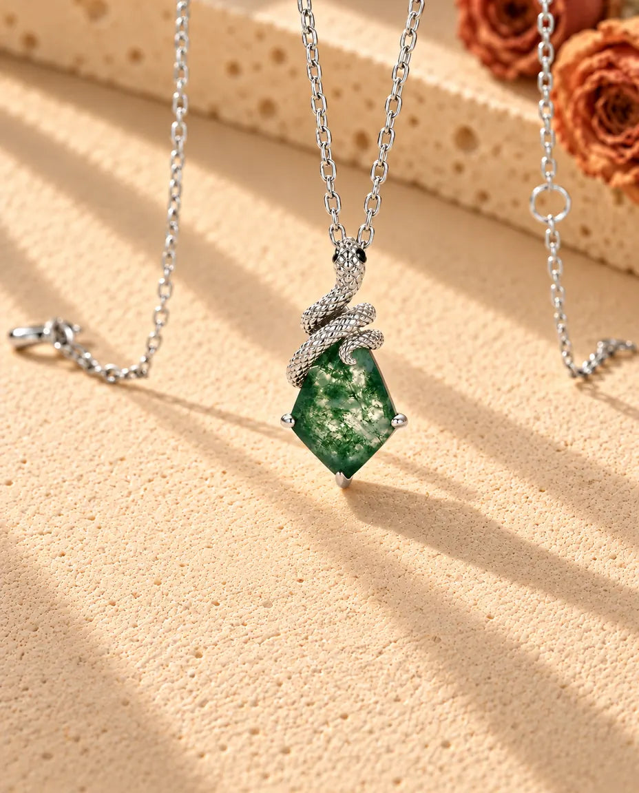 Snake Moss Agate Necklace in 925 Sterling Silver - seen at an angle on a cream textured surface