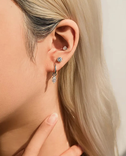 Trillion Moissanite Bezel Stud Earrings in 925 Sterling Silver - worn in the ear, close-up