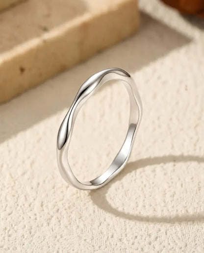 Wavy Band Ring in 925 Sterling Silver - standing upright on a cream textured surface